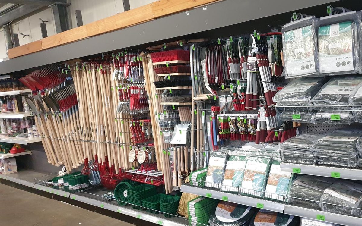 Regalwand mit Spaten, Rechen und Stielgeräten im Markt